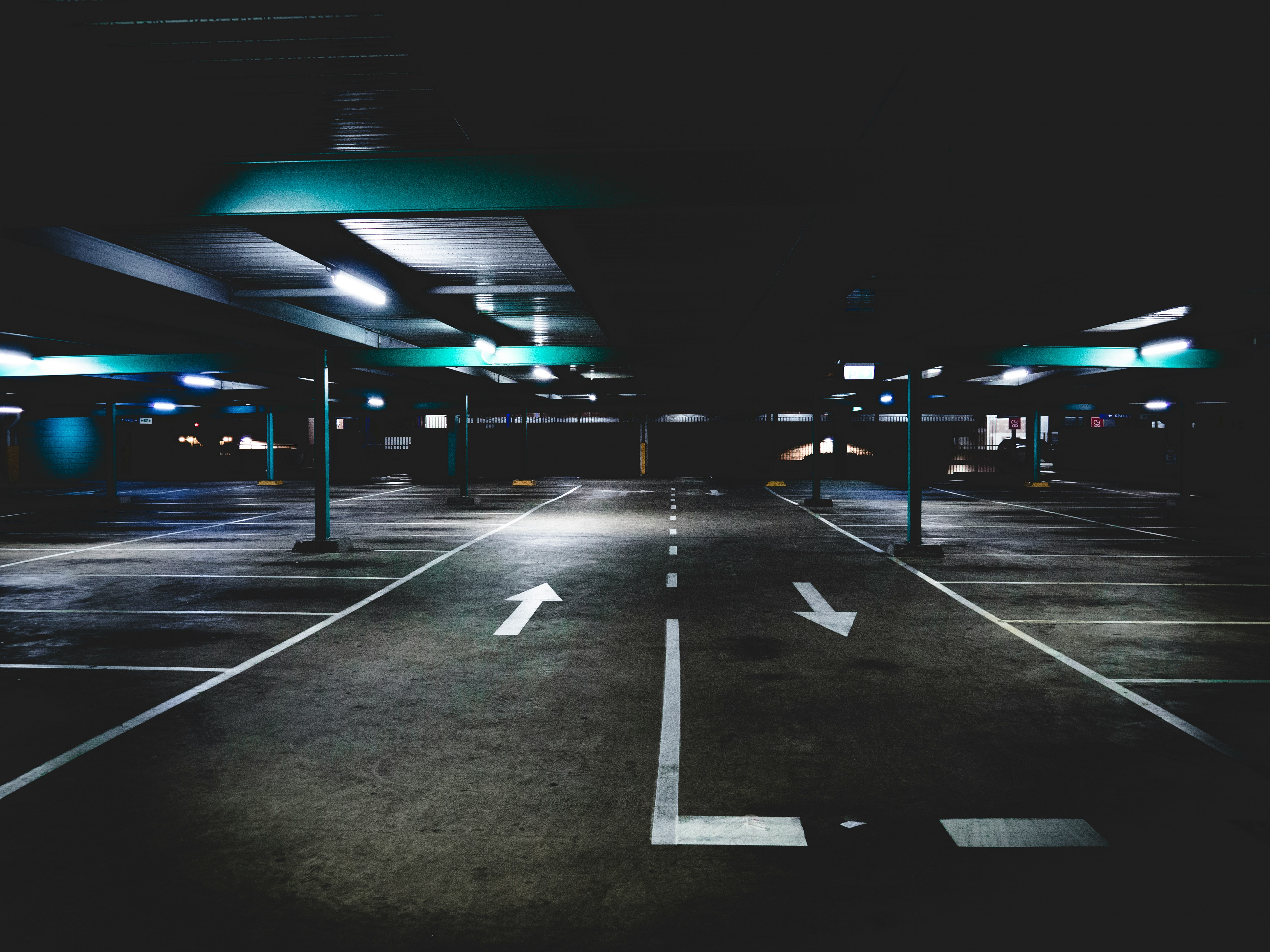 gray concrete parking area under blue building